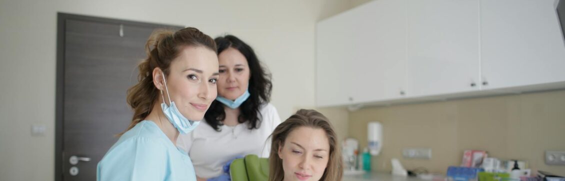 Photo by Andrea Piacquadio Dentists and patient engaging over a tablet in a clean, modern dental clinic.